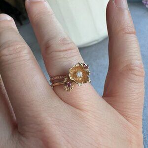 14kt gold flower ring with center diamond and 2 rubies, size about 6.25